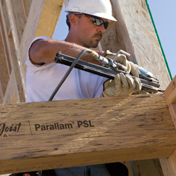 Construction worker firing a nail into Parallam PSL beams.