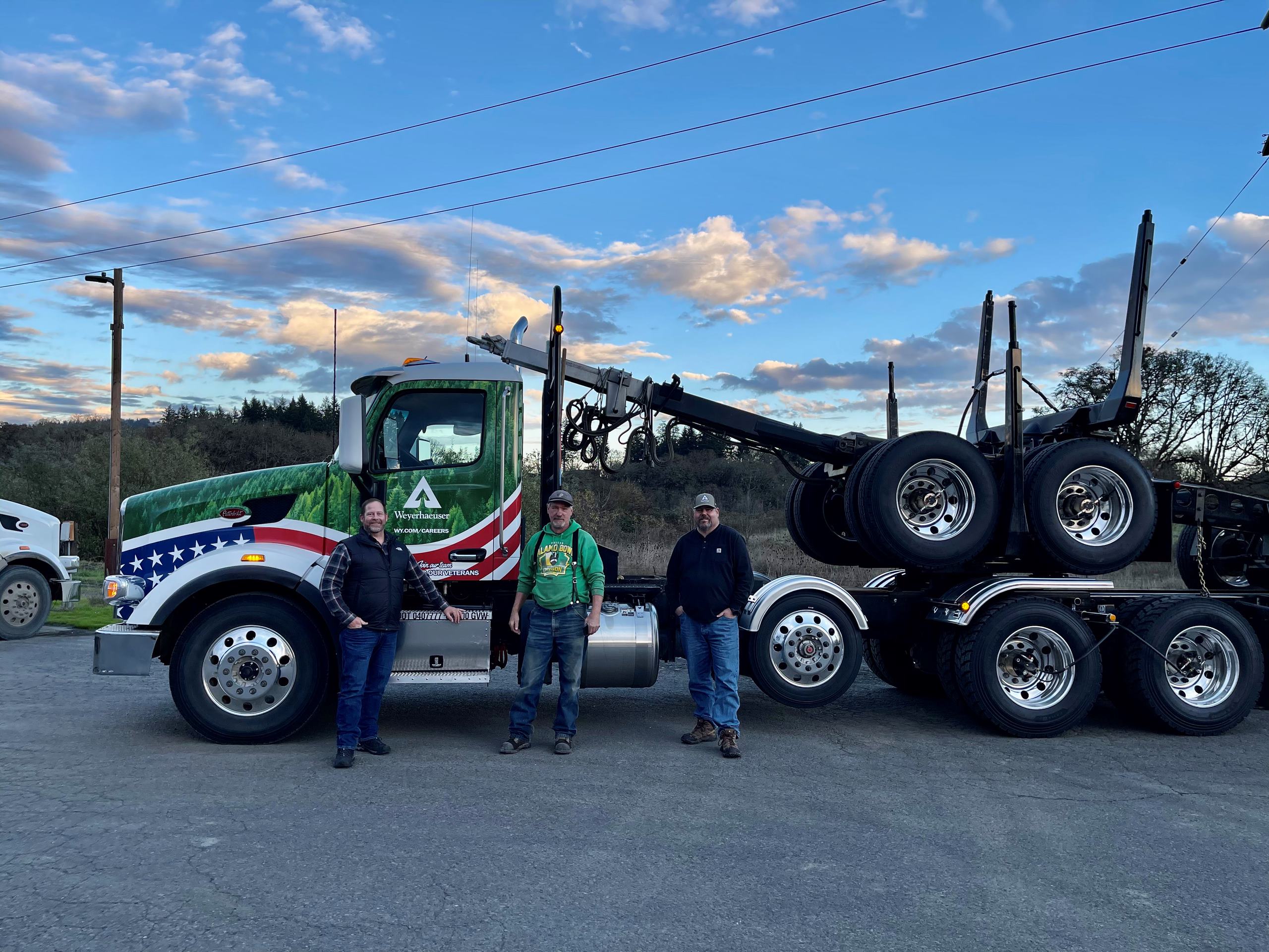 Weyerhaeuser truck with three drivers standing next to it.