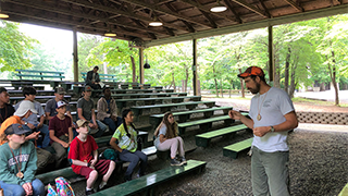 Image of Andrew Brown teaching students about trees and forestry.
