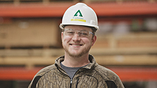 Image of a warehouse employee wearing a white Weyerhaeuser-branded hardhat.