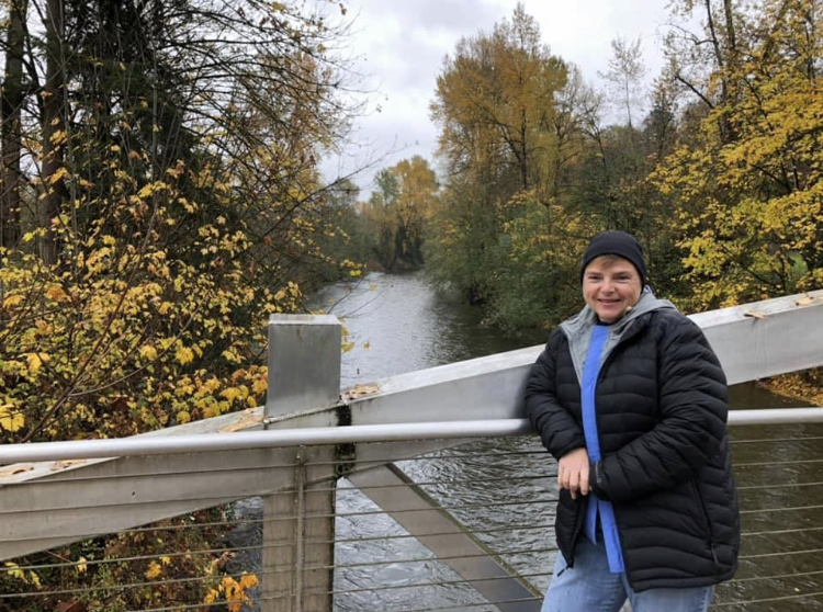 Image of Jann enjoying the fall leaves while on a walk in Maple Valley, Wash.