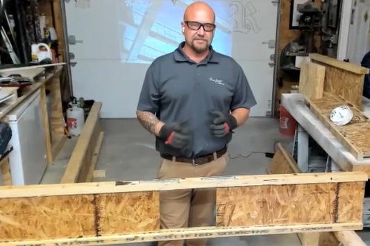 Image of a man wearing PPE in front of a TJI Joist