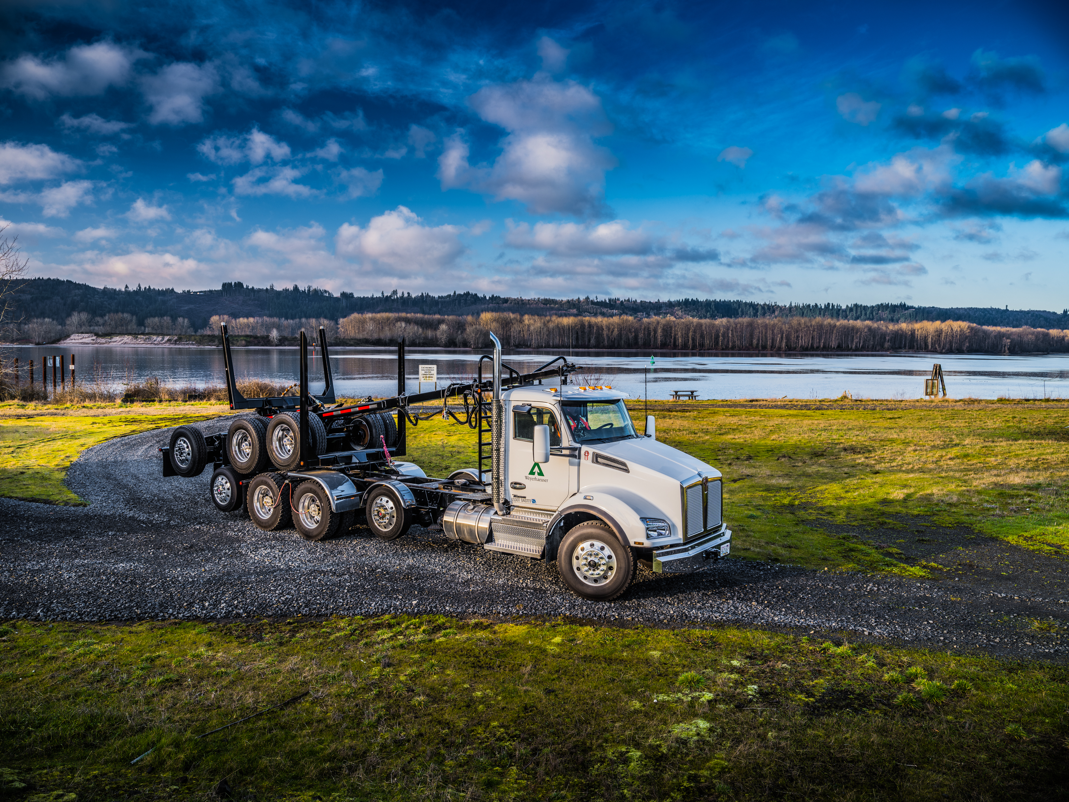 Weyerhaeuser truck driving with scenic background.