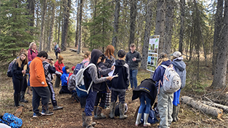 Image of Raymond Hazell, forestry intern at Grande Prairie, engaging with a class at our silviculture station.