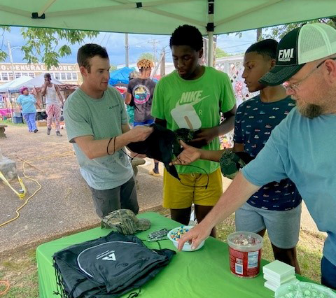 Image of employees handing out swag to community members during the Sawmill Festival in July.