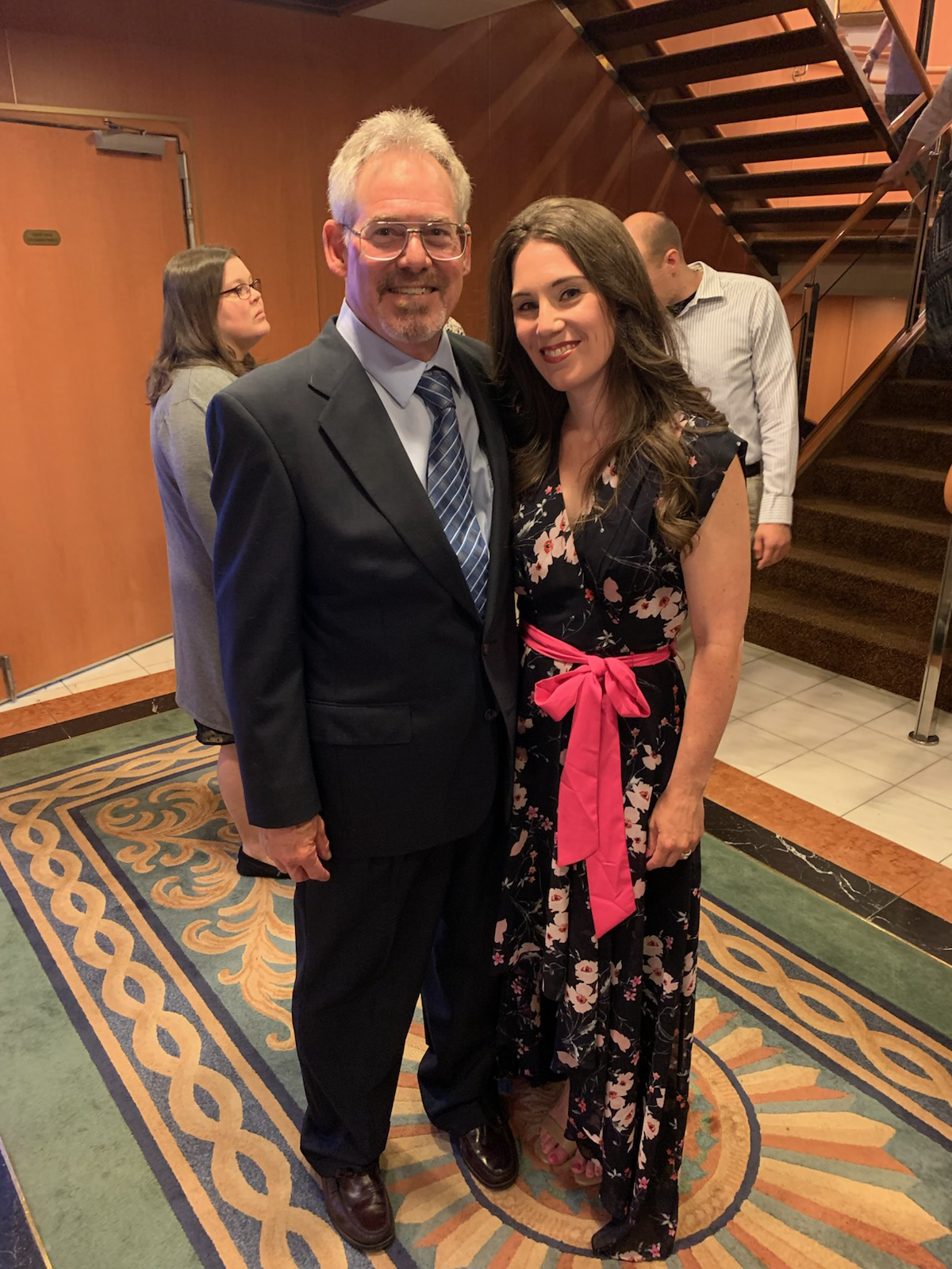 Image of Leta and her father. Leta is wearing a black floral dress with a pink bow around the waist. 