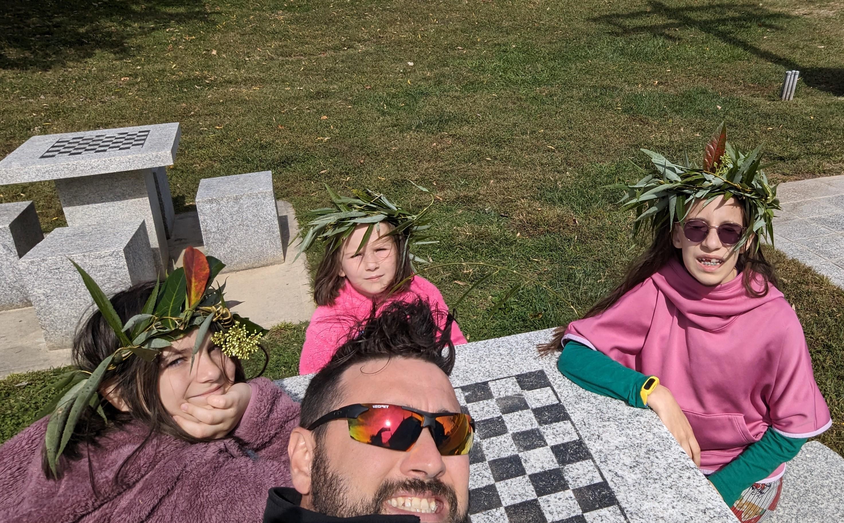 Image of James and his daughters exploring Mount Airy, N.C. The girls are each wearing nature headdresses the family made.