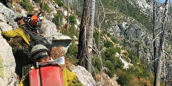 Image of Dylan hiking to a remote fire with his crew.