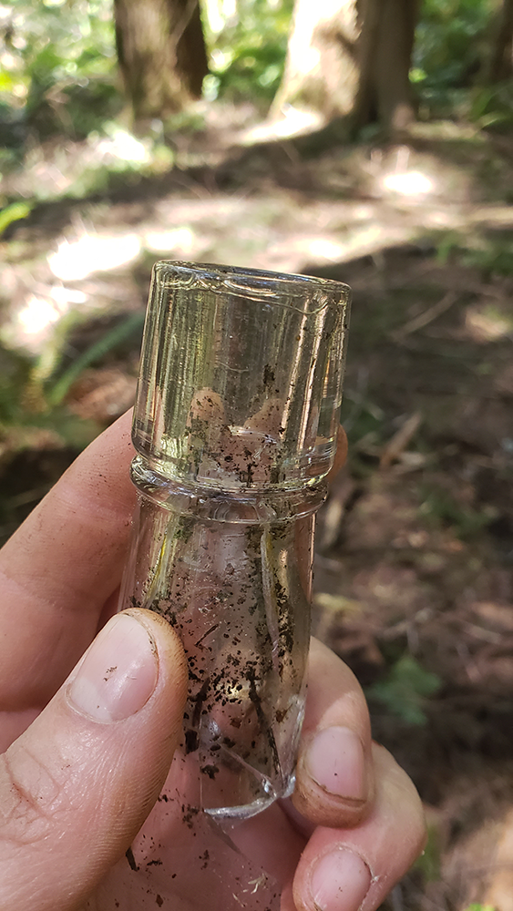 Fragment of thick glass bottle with seams stopping before the lip, indicating pre-machine production.