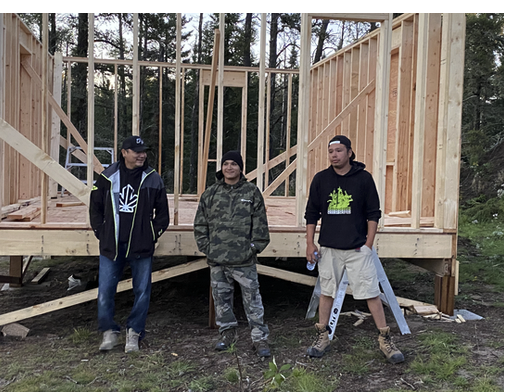 Image of center volunteers taking a break last summer after framing a permanent structure for the healing center.