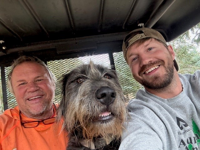 Image of Steve, a fluffy dog and his colleague in the cab of a vehicle.