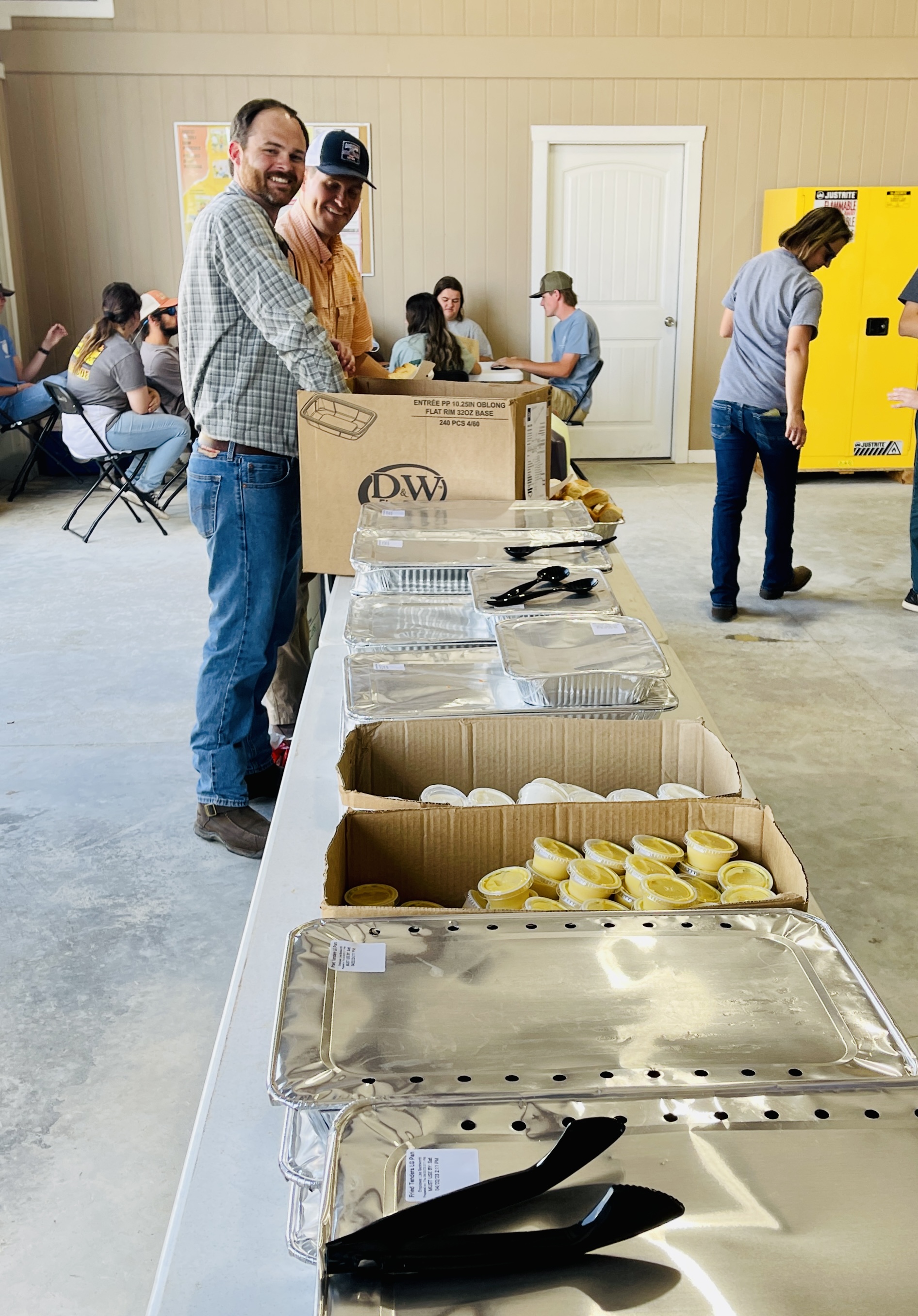 Image of Tyler Pope, land asset manager, and Luke Burklew, Coastal Piedmont wood flow manager, setting up a catered lunch for participants.