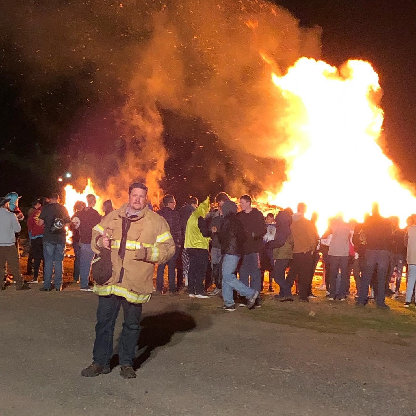 Image of George at the Sweet Home High School Homecoming bonefire with a fire truck for safety.