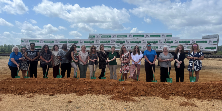 Image of Cindy and the logging team at the groundbreaking ceremony at our new plant in Arkansas. They are all standing behind a pile of dirt with ceremonial shovels.