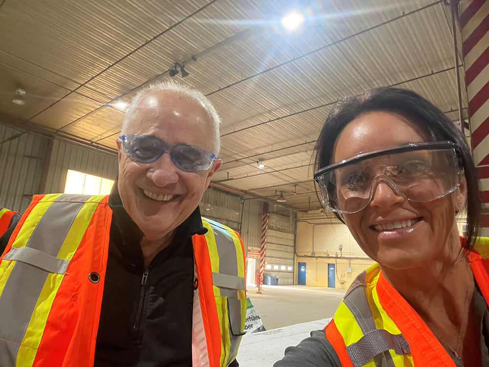 Courtney McKee smiling alongside Luiz Oliveira, technical advisor and mentor, at a company event.