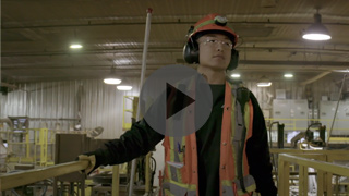 Image of a warehouse employee wearing a hardhat and high-visibility vest.