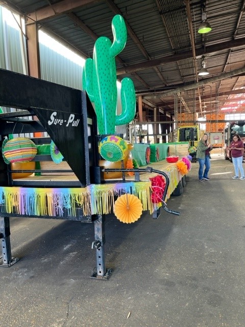 Image of employees decorating a flatbed trailer to create a float for the Zwolle Tamale Fiesta parade.
