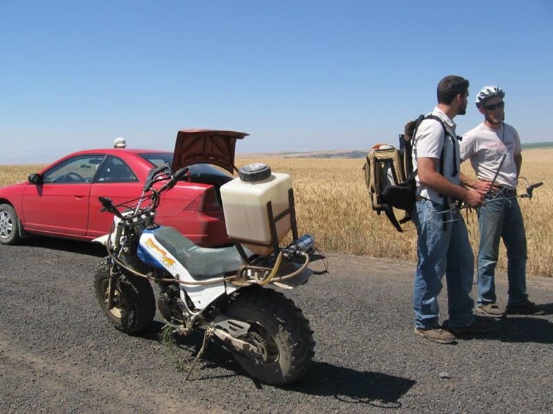 Erik, left, talks with local growers in Genesee, Idaho, for his dissertation research. He’s wearing a spectroradiometer backpack, which was used to take validation reflectance measurements from the top of the canopy of the wheat field.