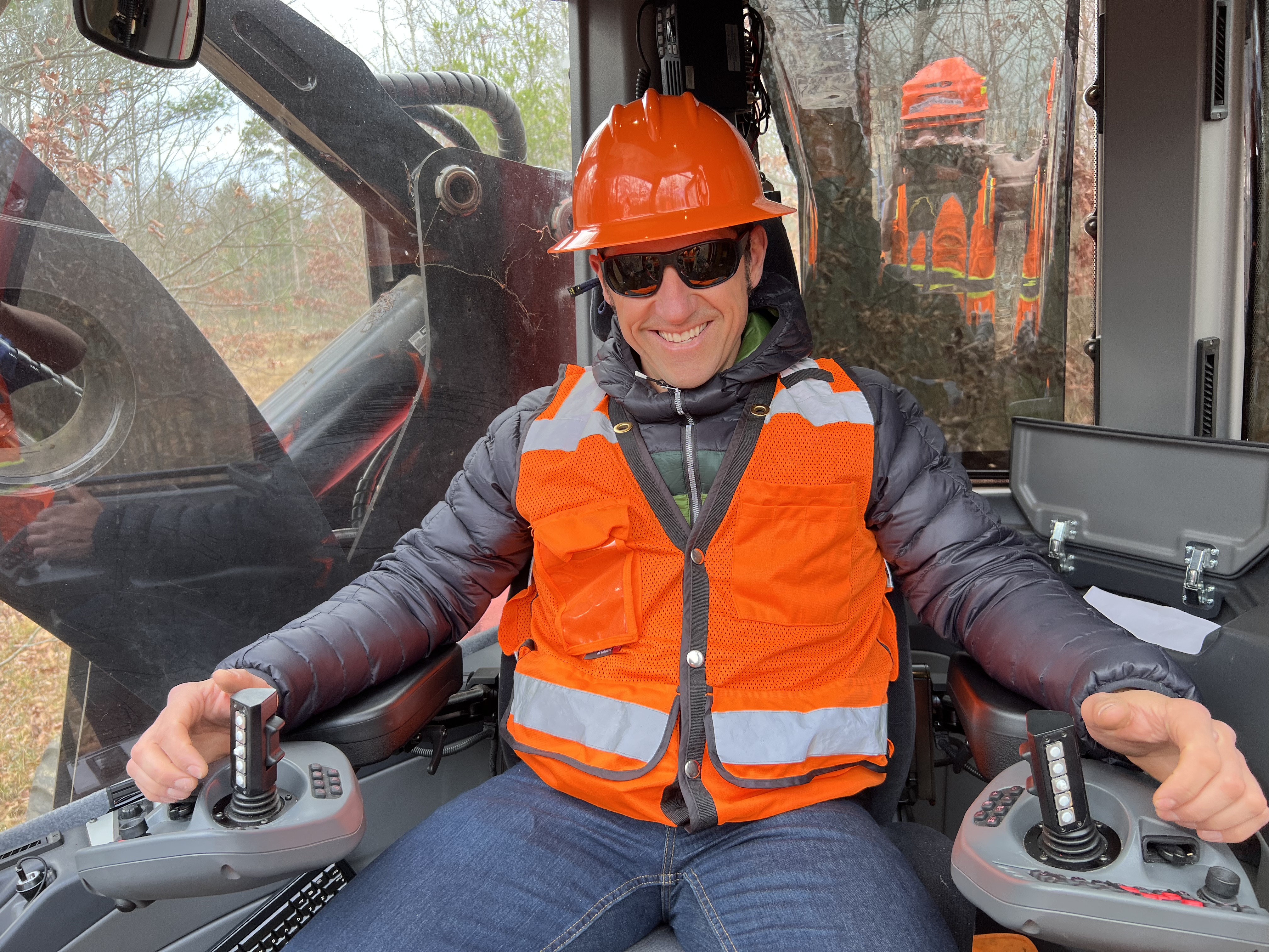 Image of Jared Richardson taking the seat of a new cut-to-length harvester during a site visit in Grayling, Michigan.