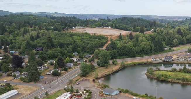 This image shows another view of the same area, but with a closer view of the clearing. It is a clearing of all trees and currently is dirt that has been leveled and readied for housing to be built.