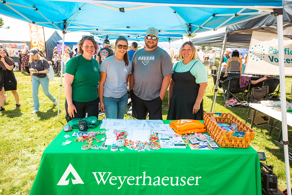 Image of employees standing at the Weyerhaeuser booth at the festival.