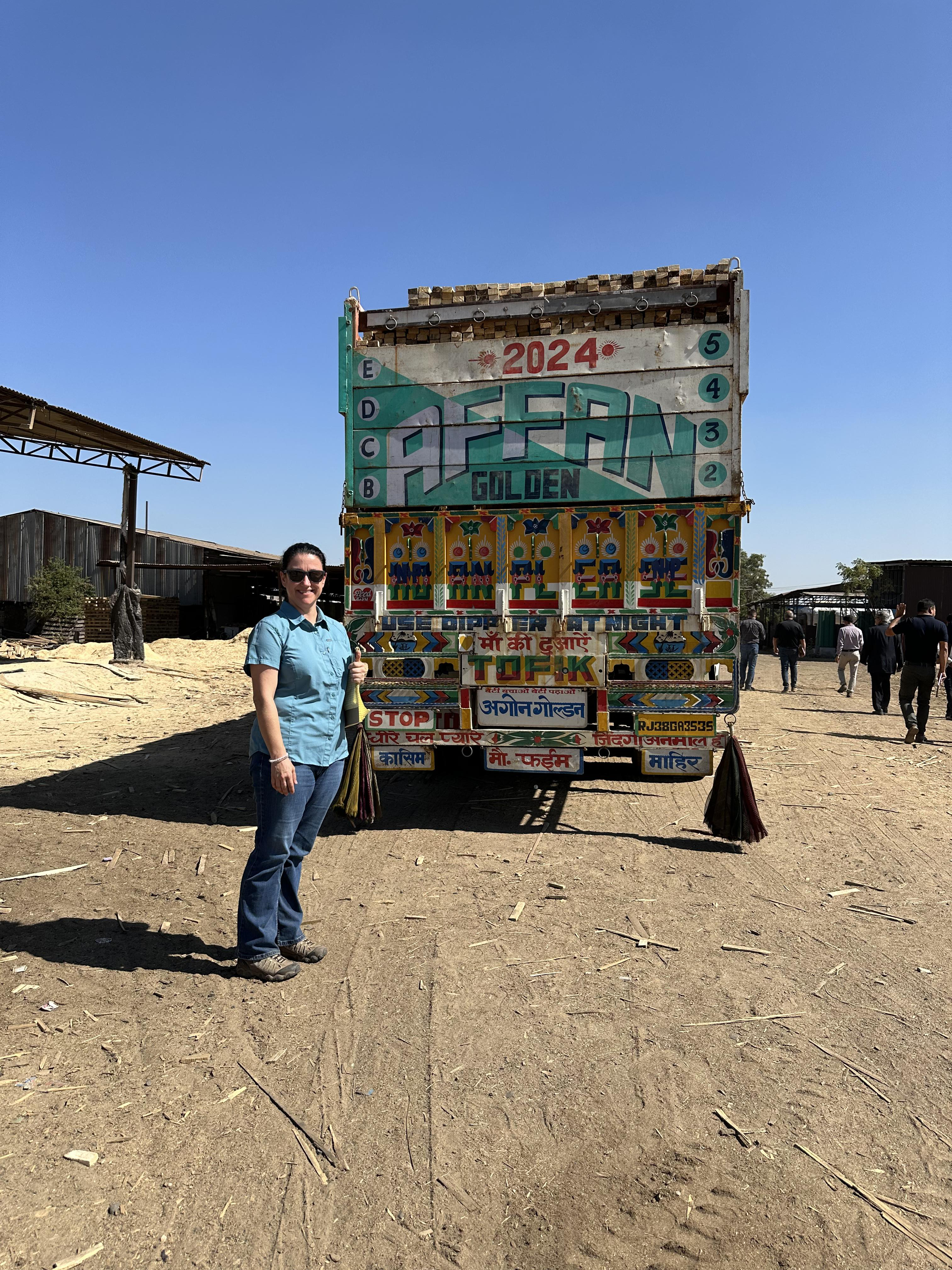 Kelly stands in front of a colorful truck while visiting India. 