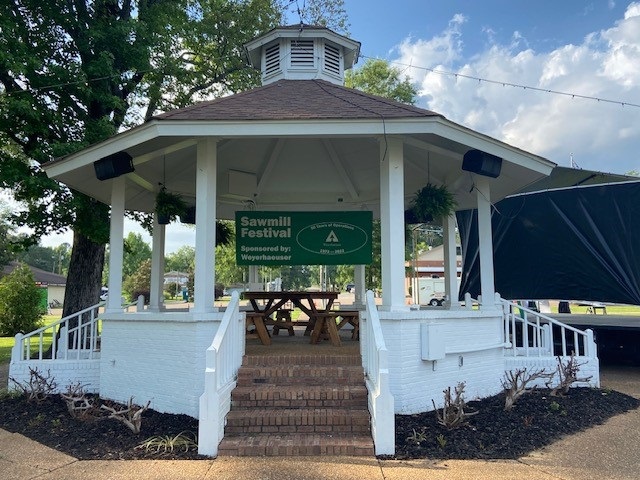 Image of a gazebo with a Sawmill Festival banner hanging from it.