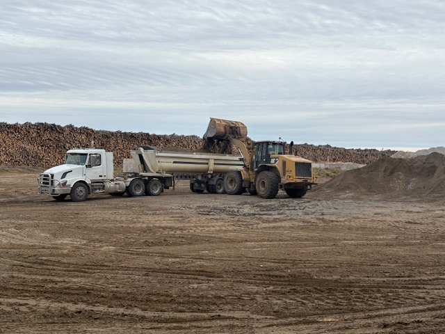 Image showing ash being put into a large dumptruck using a front-loader.