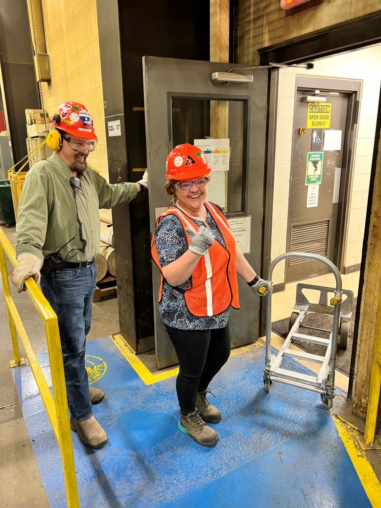 Image of Buckhannon employees showing off their personal protective equipment. Each employee is wearing hardhats, protective goggles, gloves and steel-toed boots. 