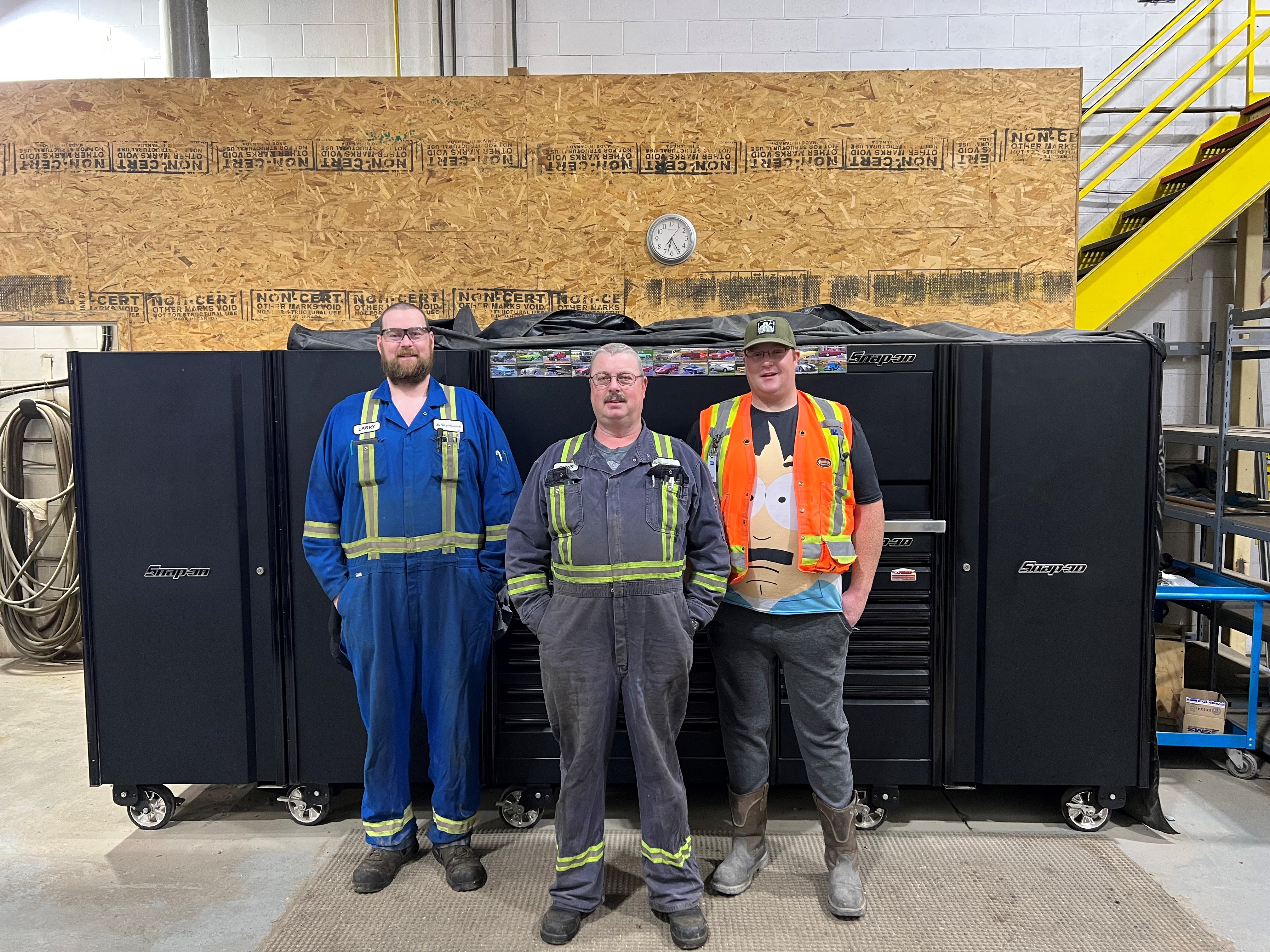 Image of Larry with his dad, Chris, and his brother, Johnathan, in front of Chris' toolbox, which is just over six feet tall.