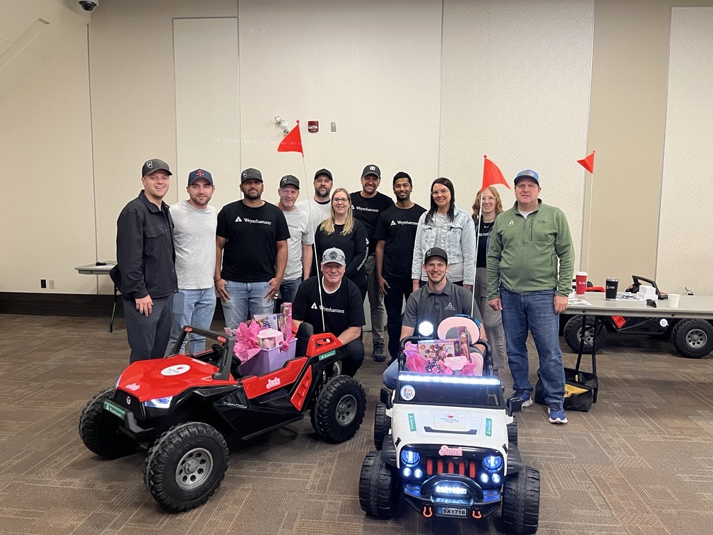 Image showing Matt, far right, and his colleagues with two vehicles they assembled for the Go Baby Go charity.