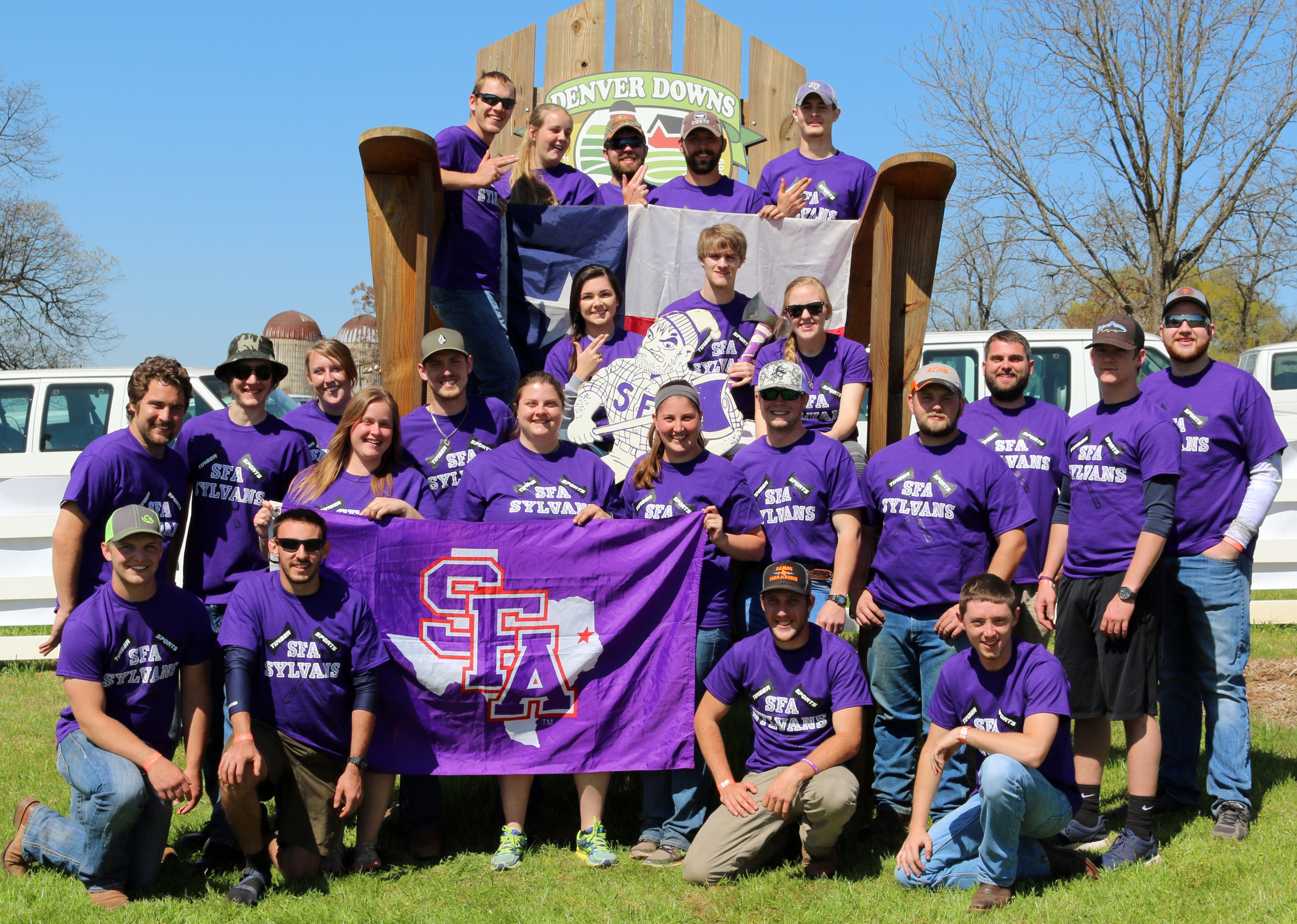 Image of Chelsea Lopez, center, holding the SFA flag, with the 2016 timbersports team she coached.