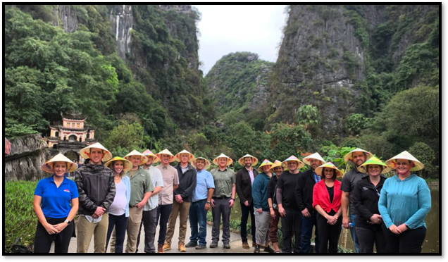 Image of the REAL Montana class participants on tour in Vietnam. All participants are wearing traditional Vietnamese headwear.