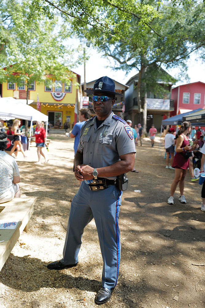 Image of a police officer standing on the streets of Philadelphia, Miss., during the Neshoba County Fair.