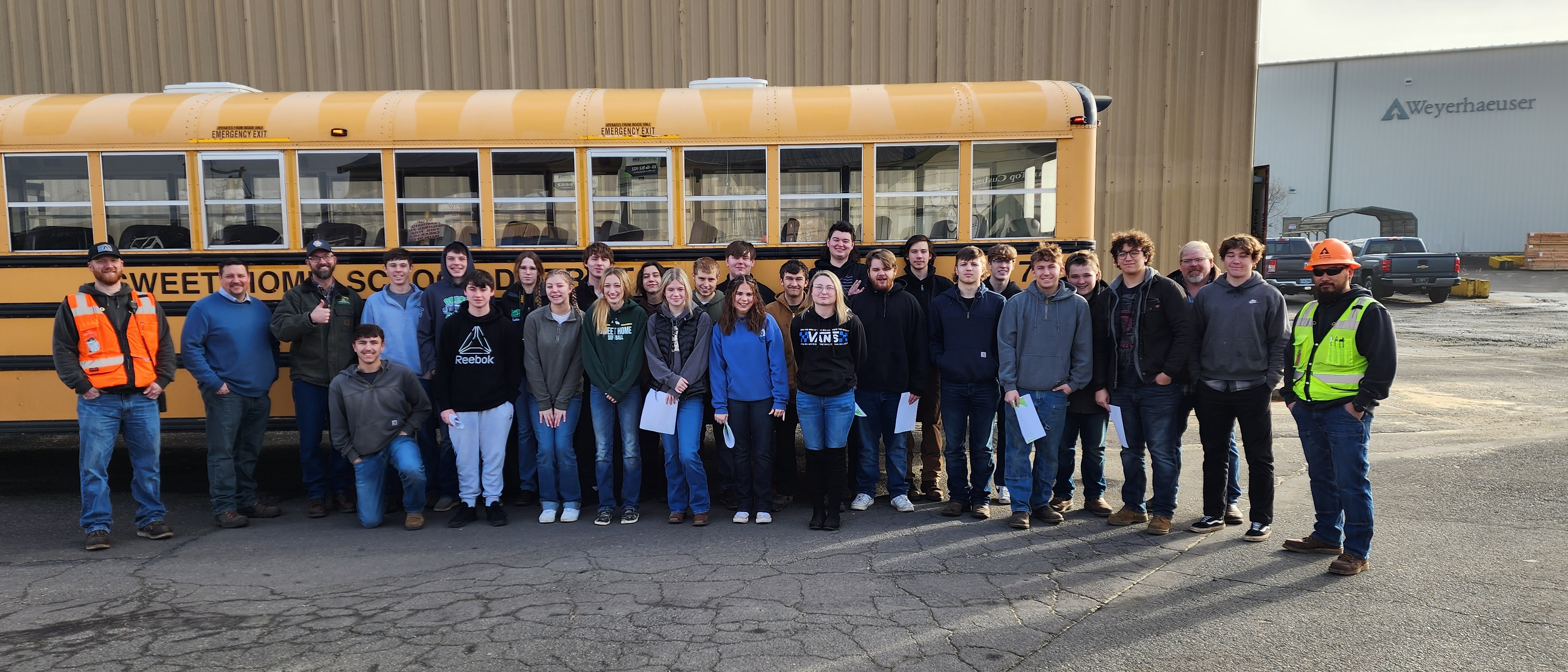 Image of George leading a tour of the Santiam lumber mill in Lebanon, Oregon, for Sweet Home High School students.