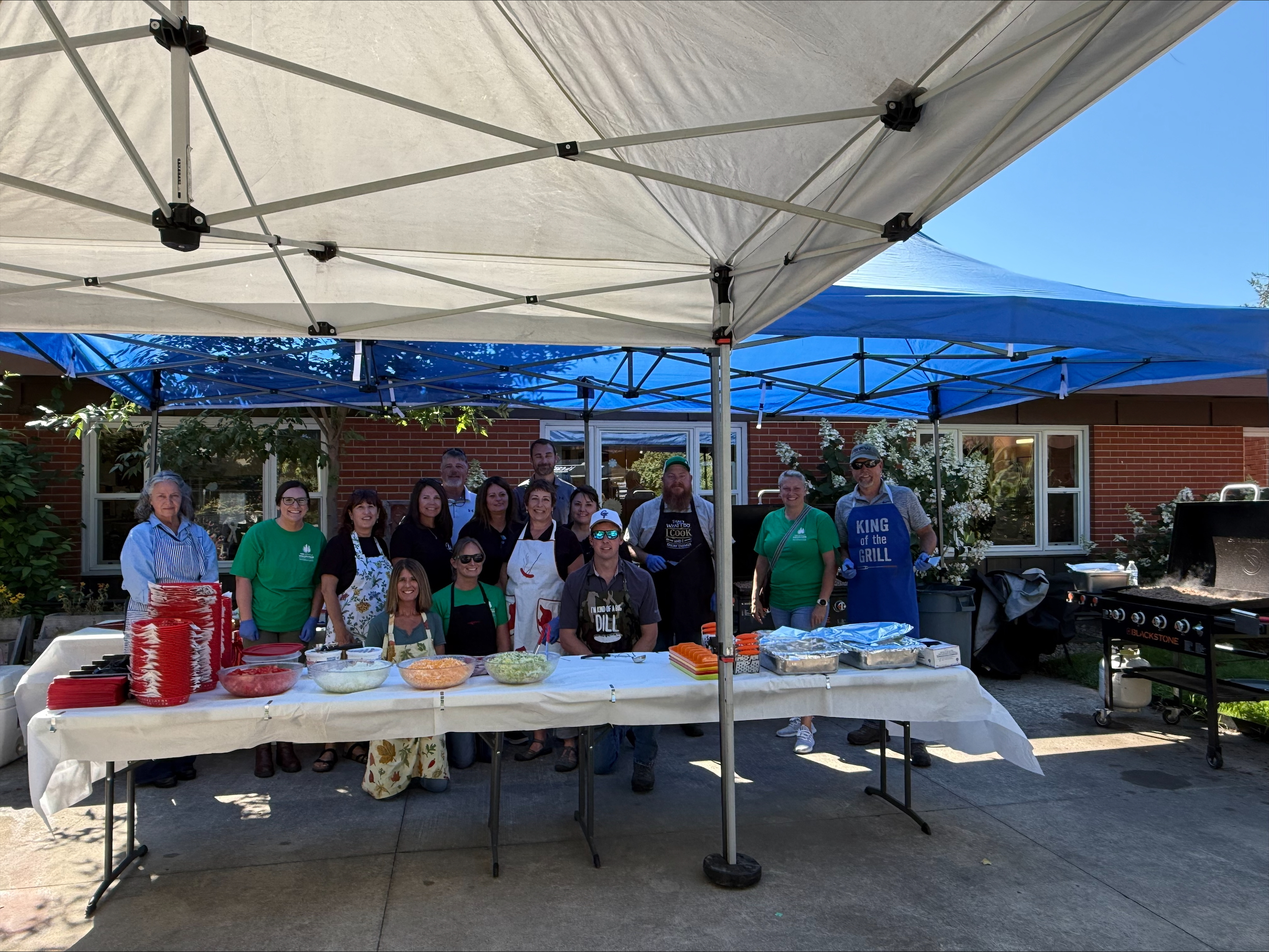 Image of Rebecca and team members serving tacos to veterans during a charity event.