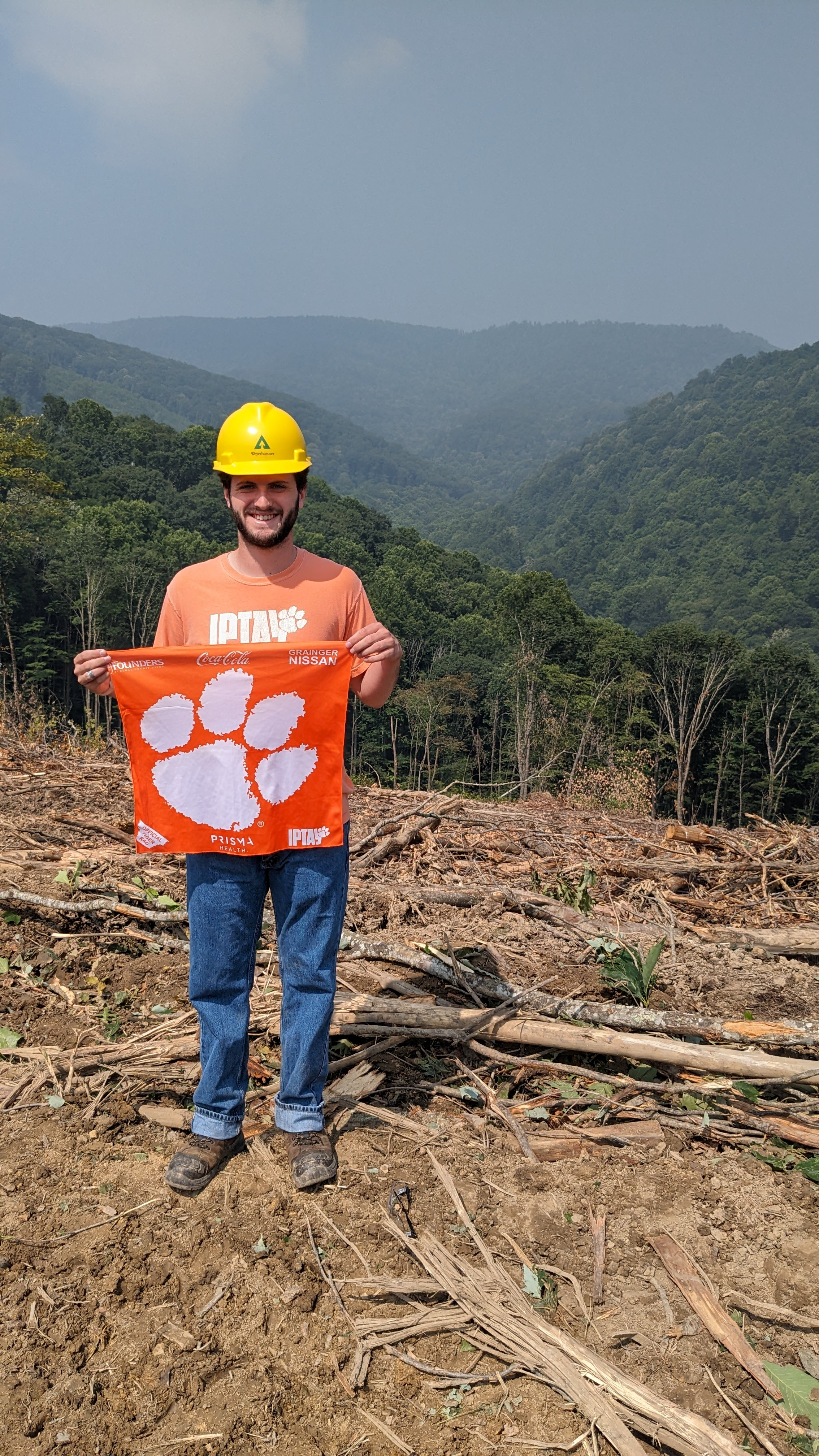 Image of Christian holding a Clemson flag in our timberlands near Lewisburg, W.V.
